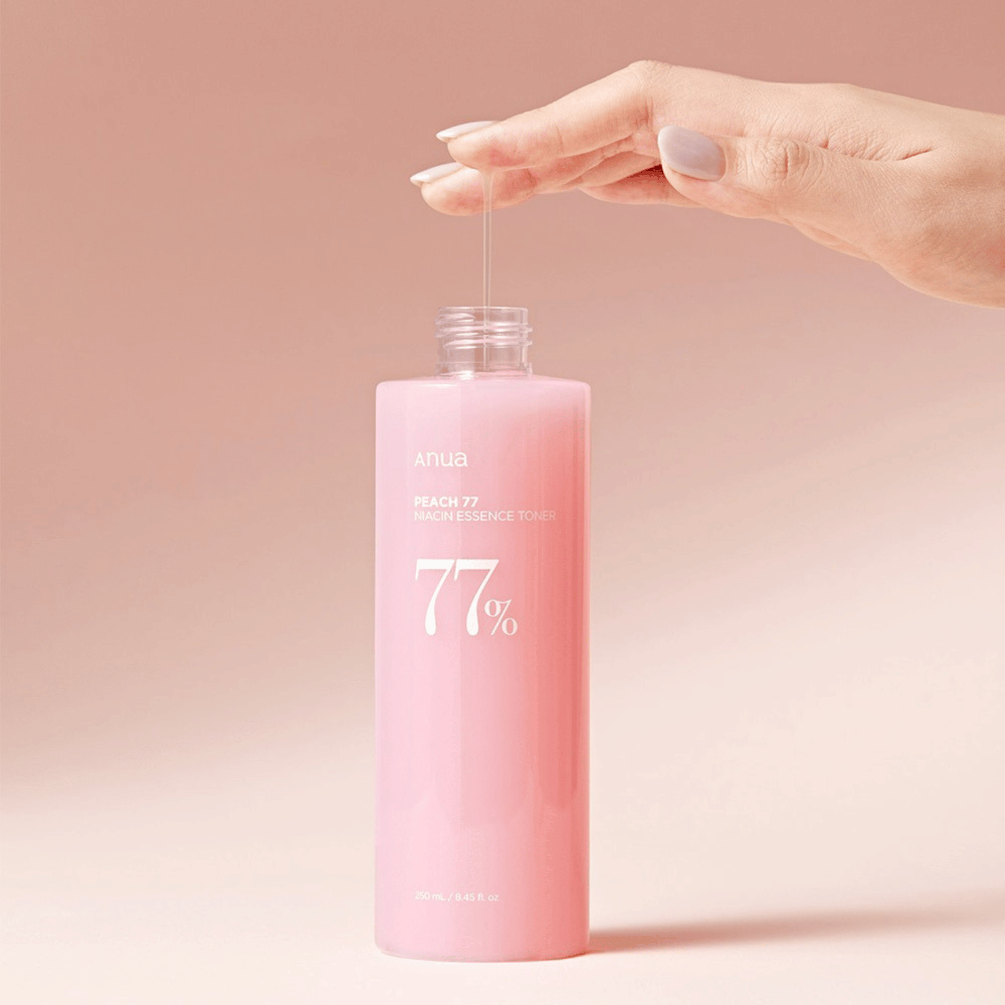Anua Peach Niacin Essence Toner mit einer Hand wird die Textur des Produkts gezigt.