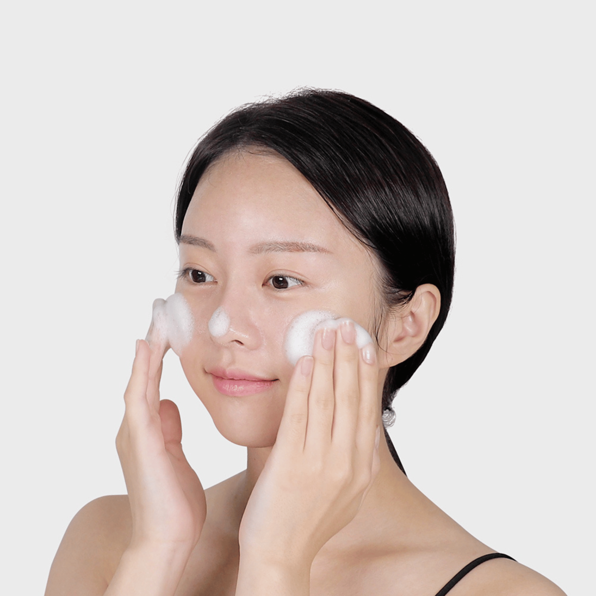 Junge Frau trägt den VT Cica Mild Foam Cleanser auf die Wangen auf, sanfter Reinigungsschaum bei empfindlicher Haut