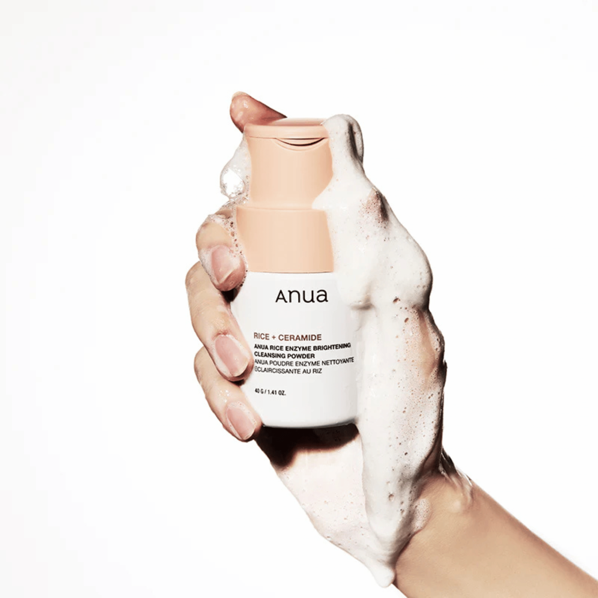 Hand mit Schaum umschließt das Anua Rice Enzyme Brightening Cleansing Powder – effektive Reinigung mit Reispuder