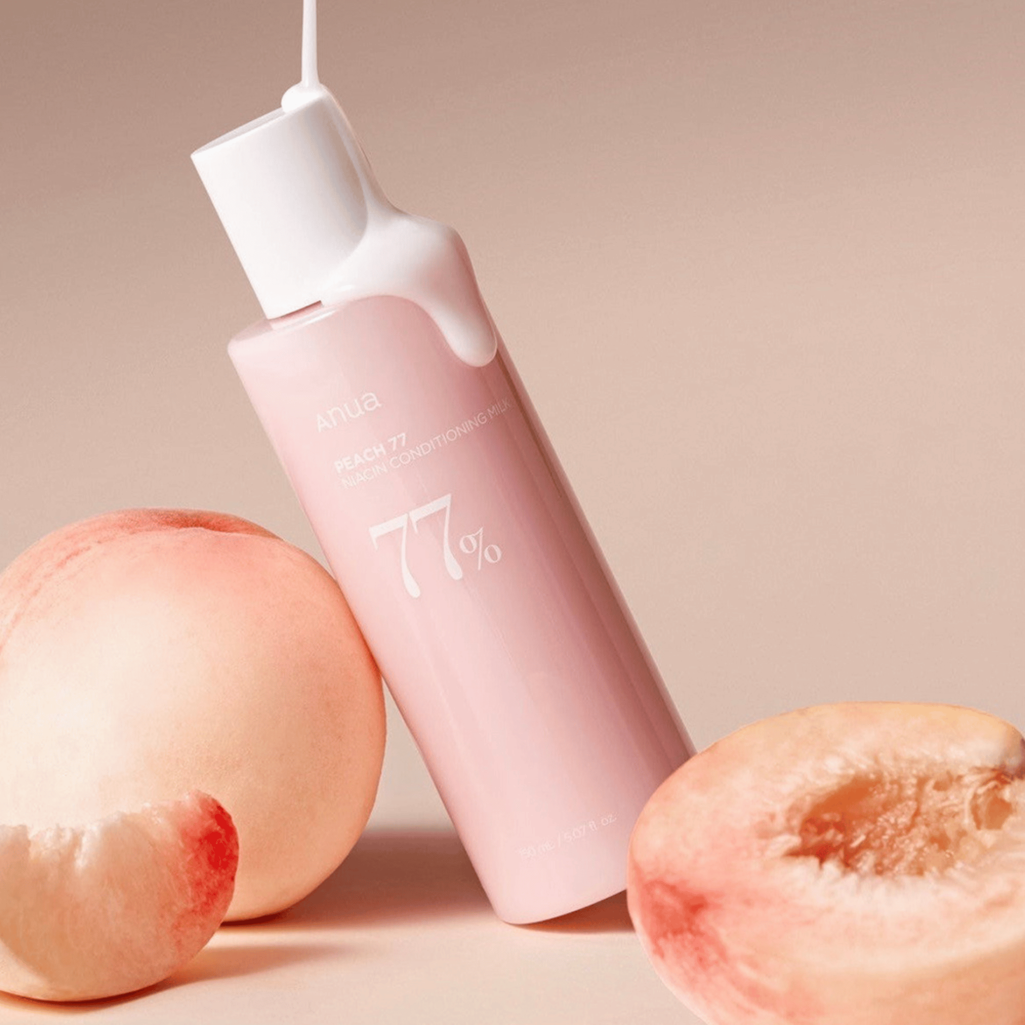 Die Anua Peach 77% Niacin Conditioning Milk zwischen 2 Pfirsichen und Abbildung der milchigen Textur