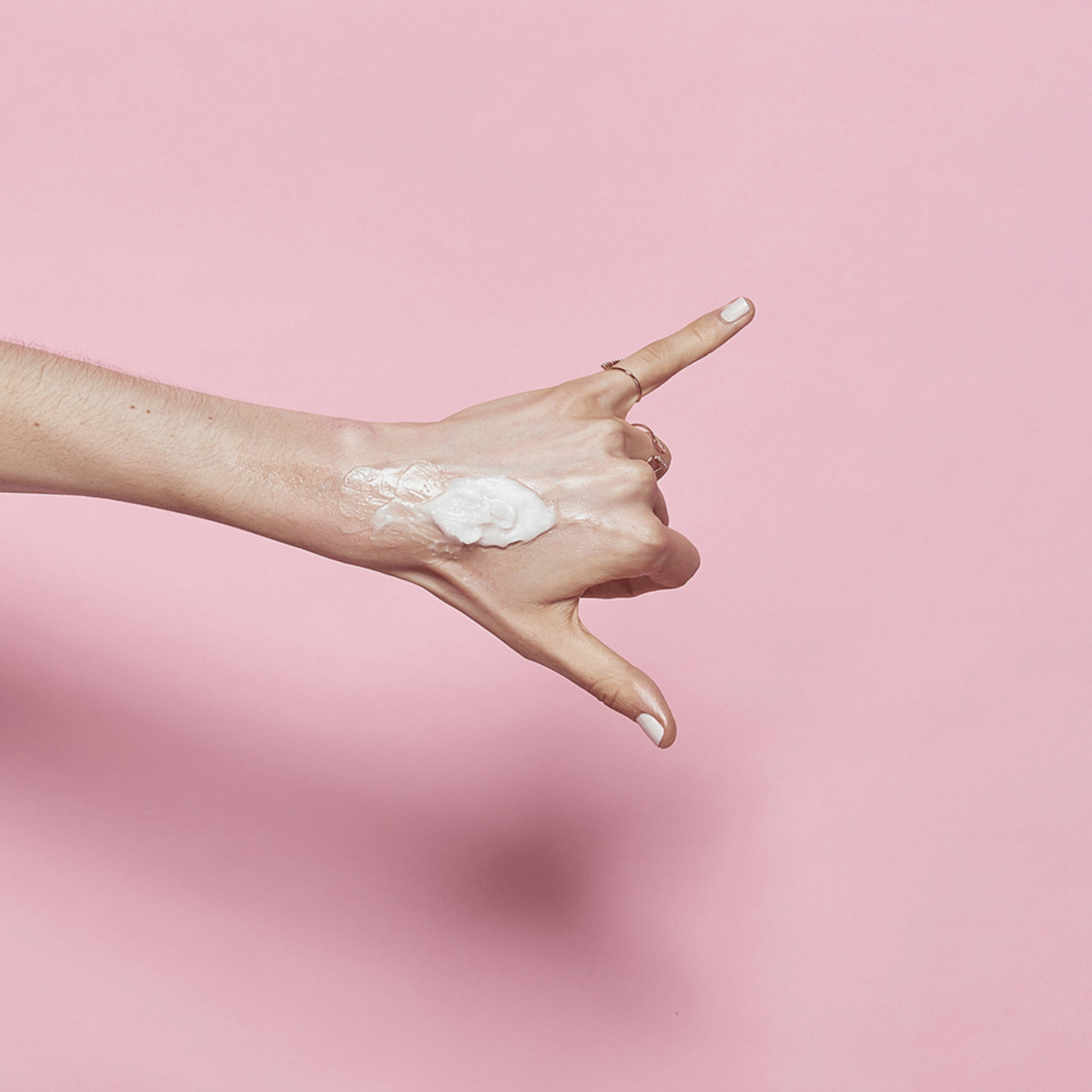 Textur des BANILA CO Clean It Zero Cleansing Balm Original auf Handrücken aufgetragen, vor rosa Hintergrund