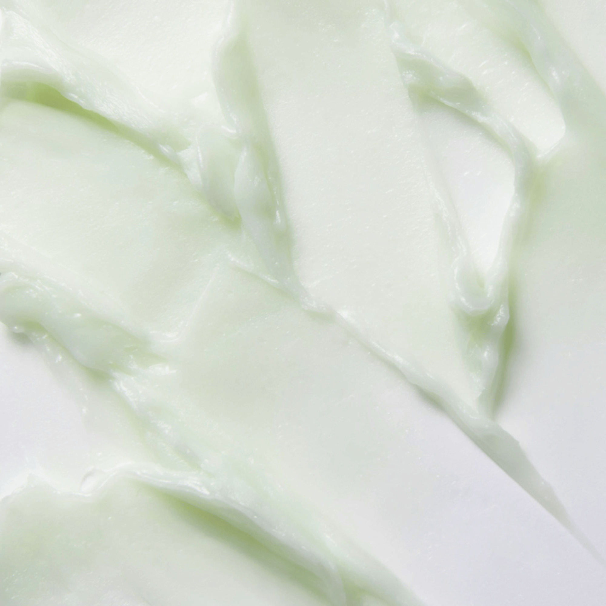 Nahaufnahme der geschmeidigen Textur des Banila CO Clean It Zero Pore Clarifying Cleansing Balm mit grünlich-weißer Farbe auf weißem Hintergrund, ideal für porentiefe Reinigung.