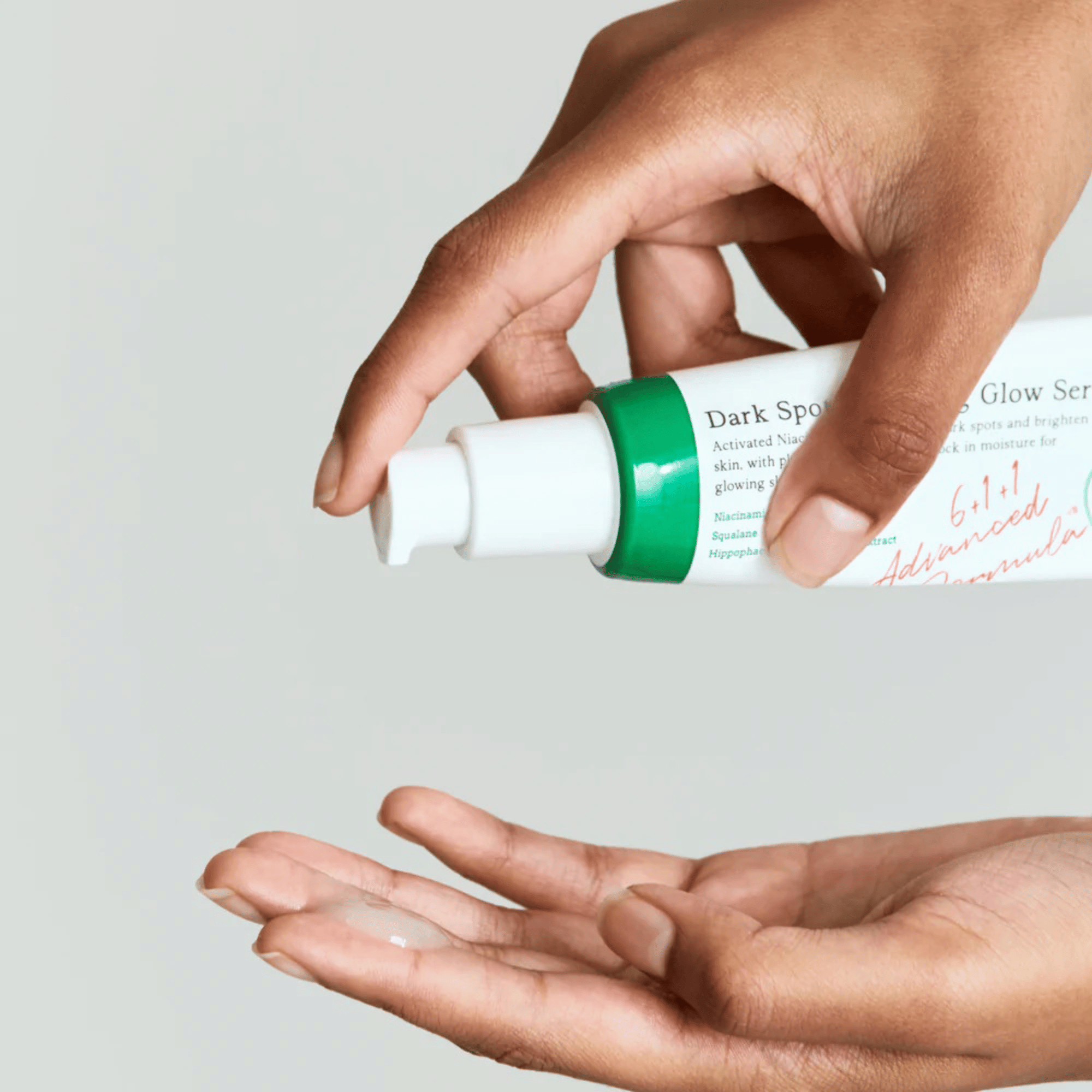 Eine Hand pumpt eine kleine Menge des AXIS-Y Dark Spot Correcting Glow Serums auf die andere Handfläche vor hellem Hintergrund