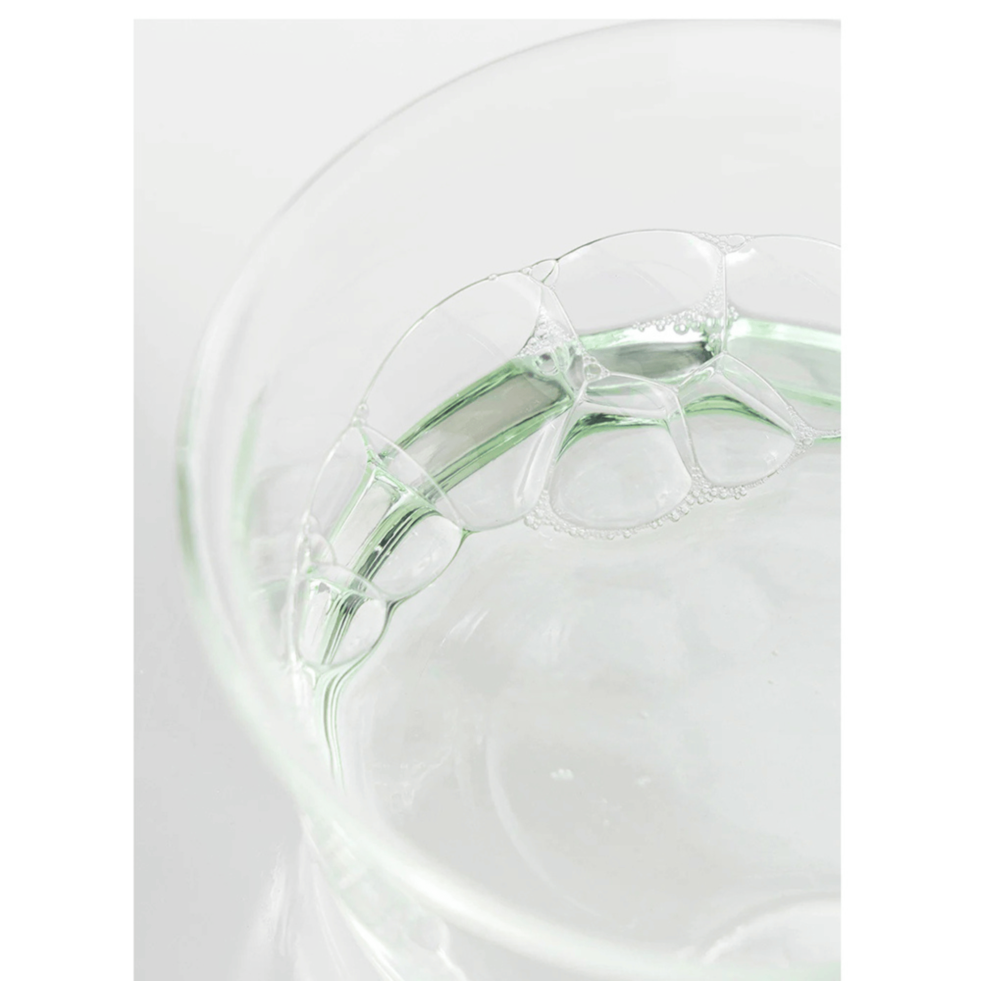 Klare, grünliche Flüssigkeit mit Schaumblasen in einer Glas-Petrischale – Textur des Toners von Beauty of Joseon