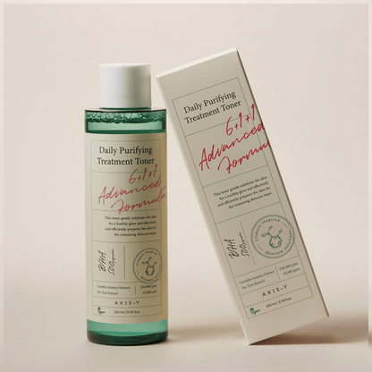 Axis-Y Daily Purifying Treatment Toner mit Verpackung aufrecht nebeneinander aufgestellt vor beigefarbenem Hintergrund