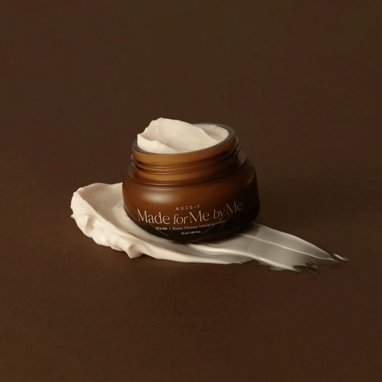 Geöffneter Tiegel der Axis-Y Biome Ultimate Indulging Cream mit großzügiger Creme auf dunklem Hintergrund – cremige Textur sichtbar