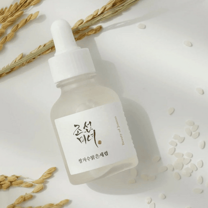 Serumflasche des Beauty of Joseon Rice + Alpha-Arbutin Glow Deep Serum mit Reiskörnern und Getreide auf weißem Hintergrund